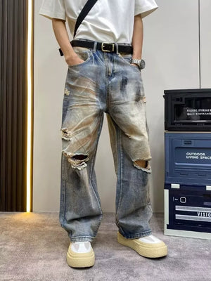 Heavily distressed vintage wide-leg jeans in blue denim with ripped details.