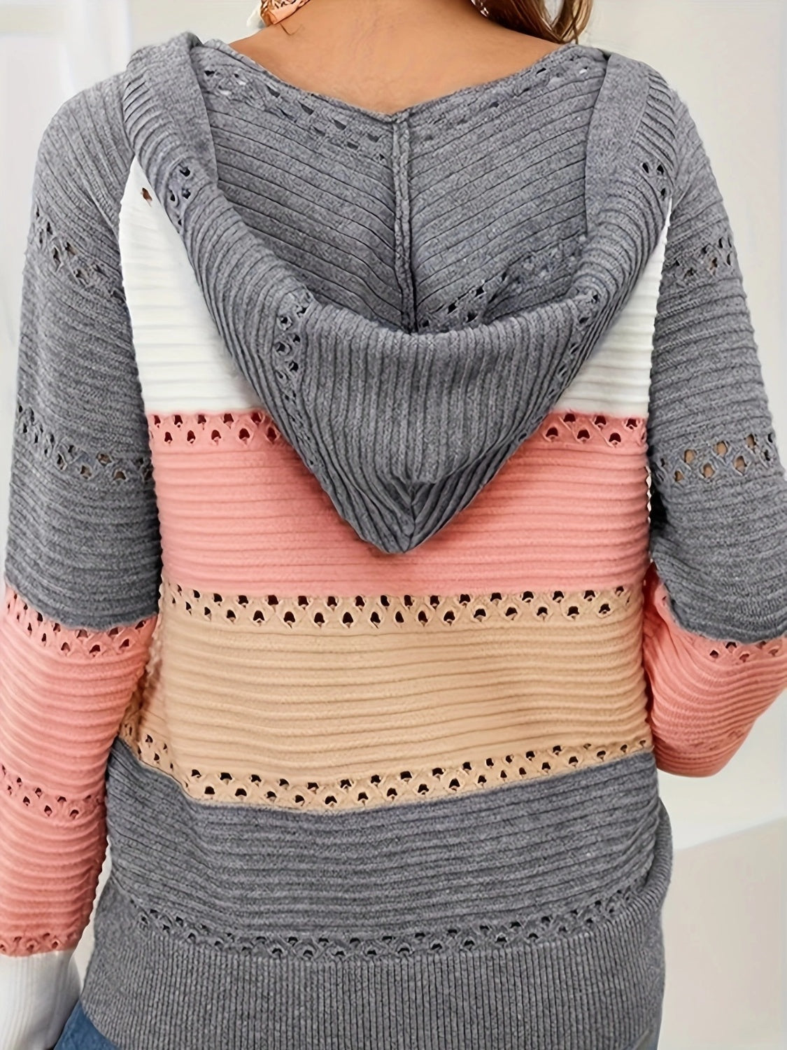 Colorblock knit hoodie with lace-up detail and cutouts in gray, white, pink, and beige.
