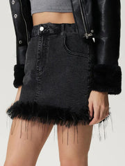 Black denim mini skirt with feather trim hem and cuffs.