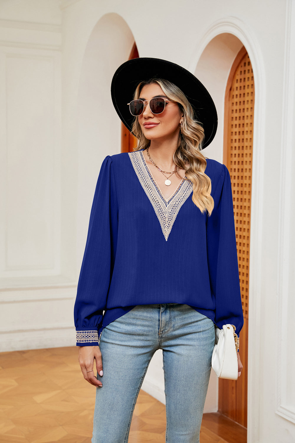 Royal blue blouson top with embroidered V-neck trim and cuffs.