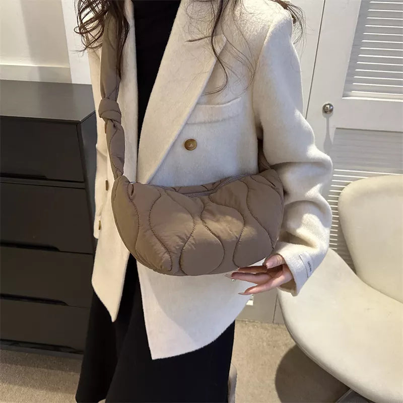 Puffy quilted crossbody bag in brown with knotted strap and abstract pattern.