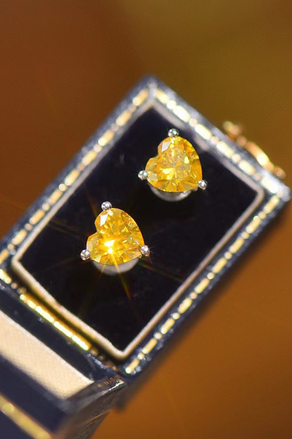 Yellow heart moissanite stud earrings in a jewelry box