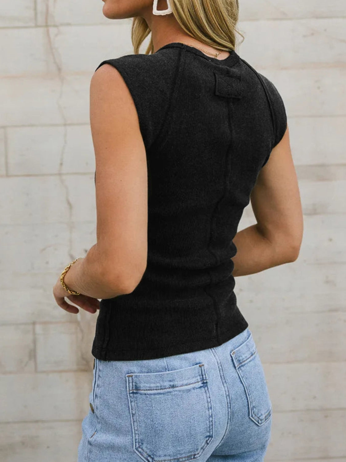 Black ribbed tank top with seamed shoulders and a cropped length.