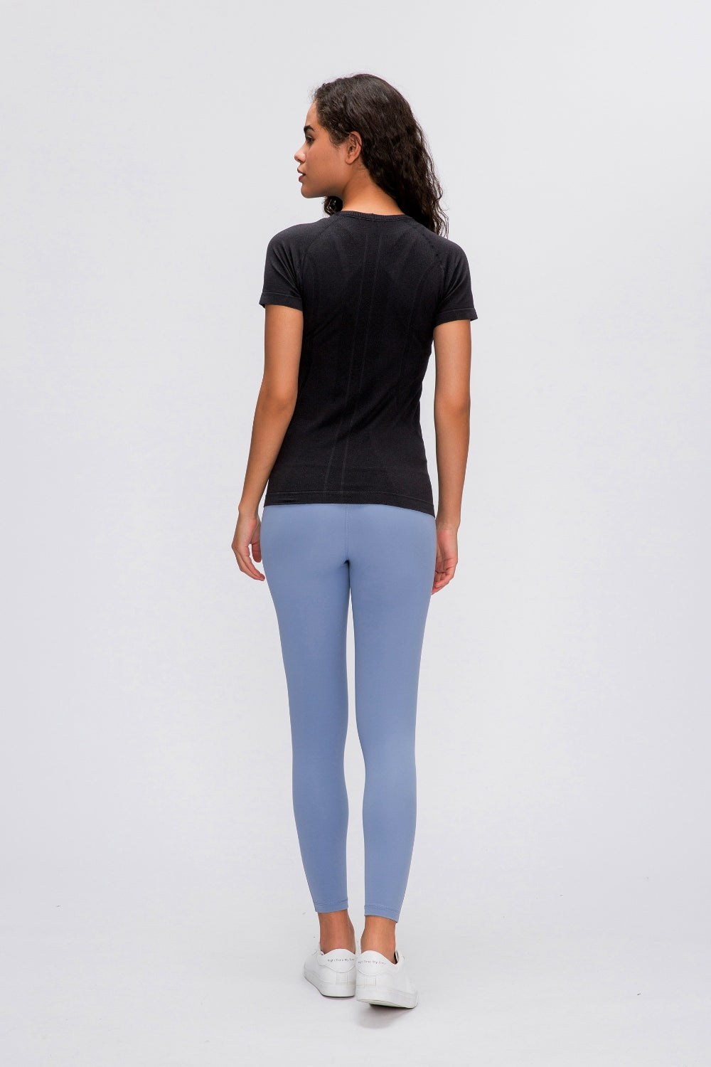 Black seamless active tee with short sleeves and subtle textured detail on back.