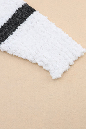 Textured stripe slouchy knit sweater in white with black stripes, showing fuzzy acrylic fabric detail.