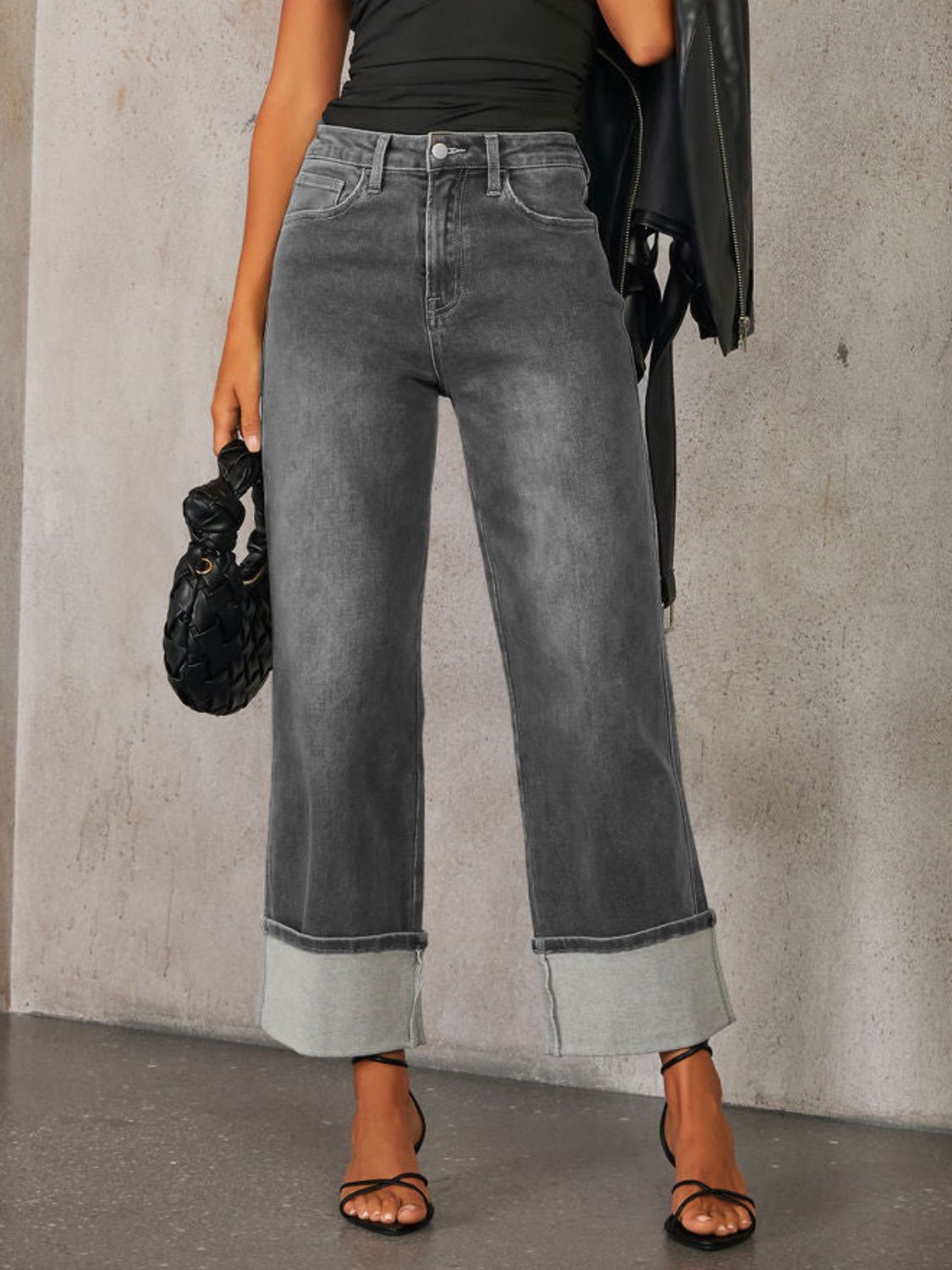 Dark wash denim jeans with wide legs and cuffed hems.