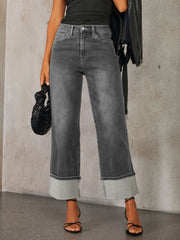 Dark wash denim jeans with wide legs and cuffed hems.