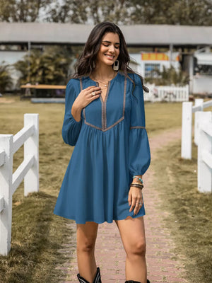 Blue notched V-neck dress with balloon sleeves and embroidered detail.
