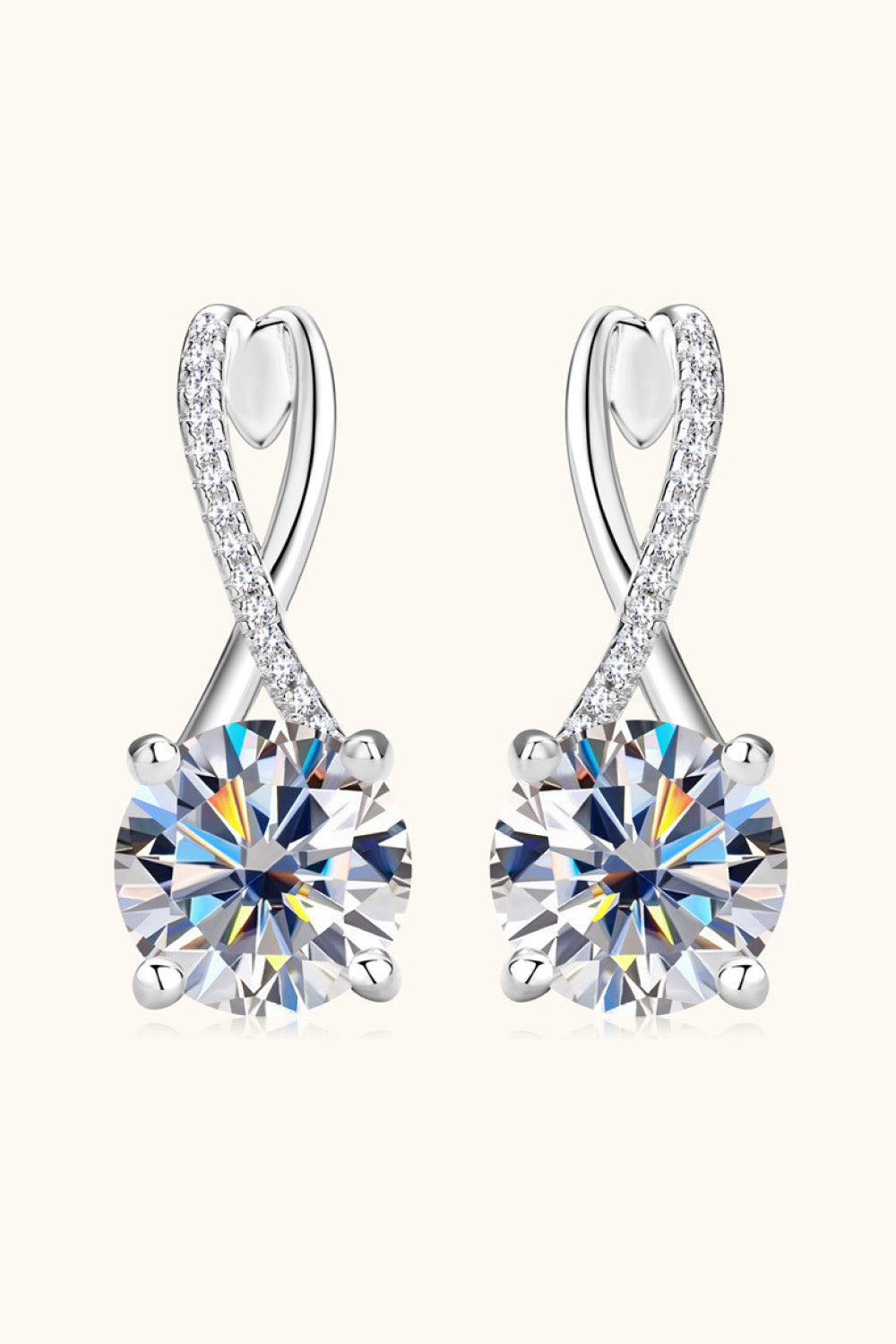 Silver crossover moissanite huggie earrings with pavé diamond accents.