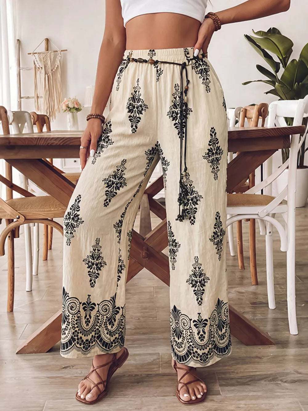 Beige wide leg maternity pants with black boho print and drawstring waist.
