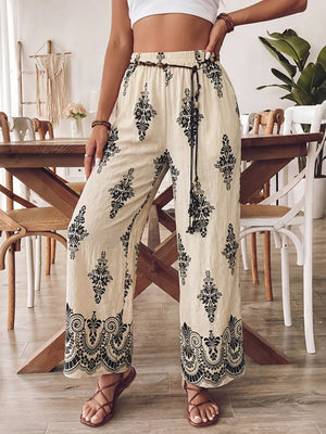 Beige wide leg maternity pants with black boho print and drawstring waist.