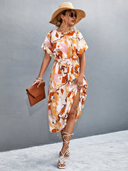 Abstract print midi dress in orange-red with tie waist and side slit.