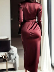 Burgundy satin maternity dress with tie waist and long sleeves.