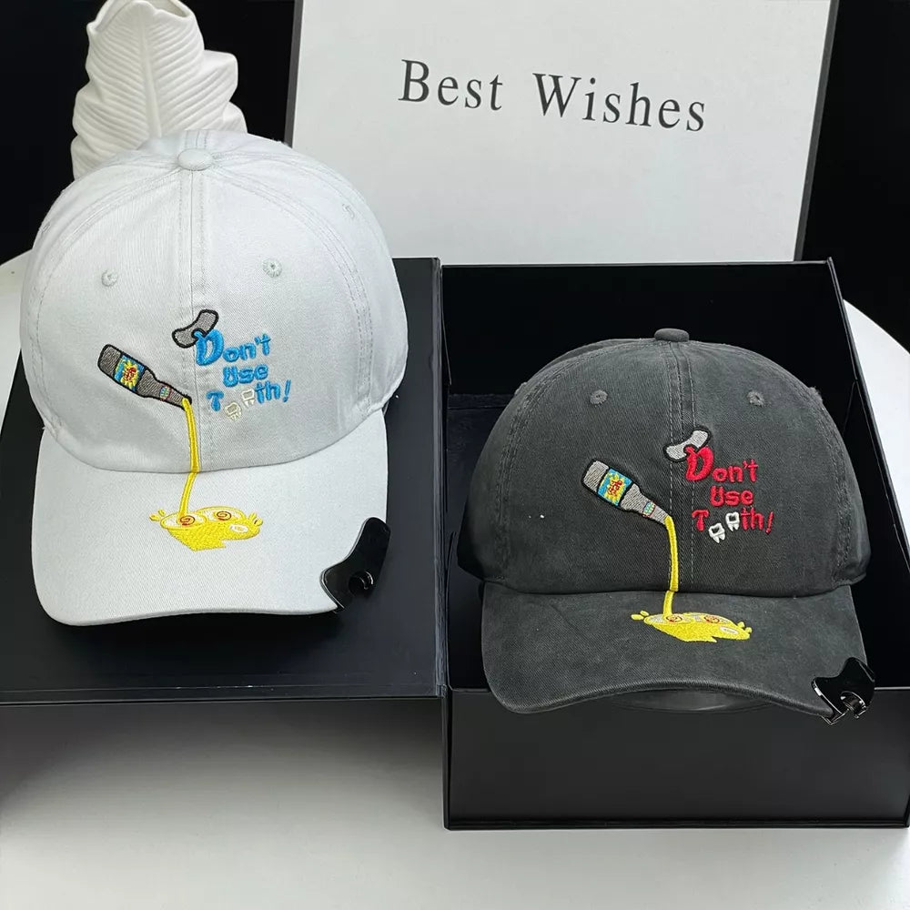 White and dark gray baseball caps with cartoon embroidery of a bottle pouring liquid.