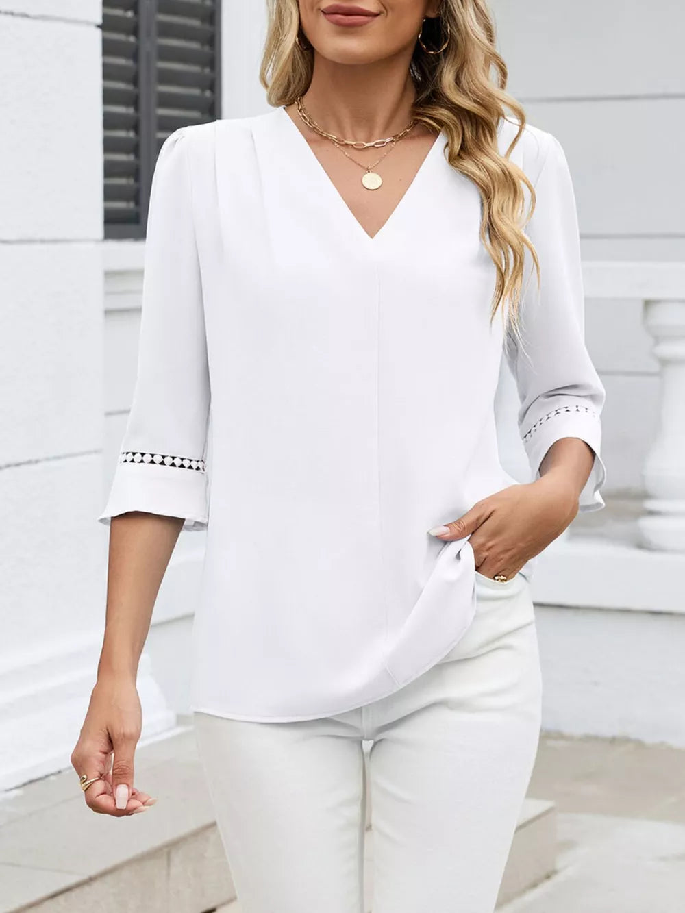 White V-neck blouse with 3/4 sleeves featuring lace trim detail at the cuffs.