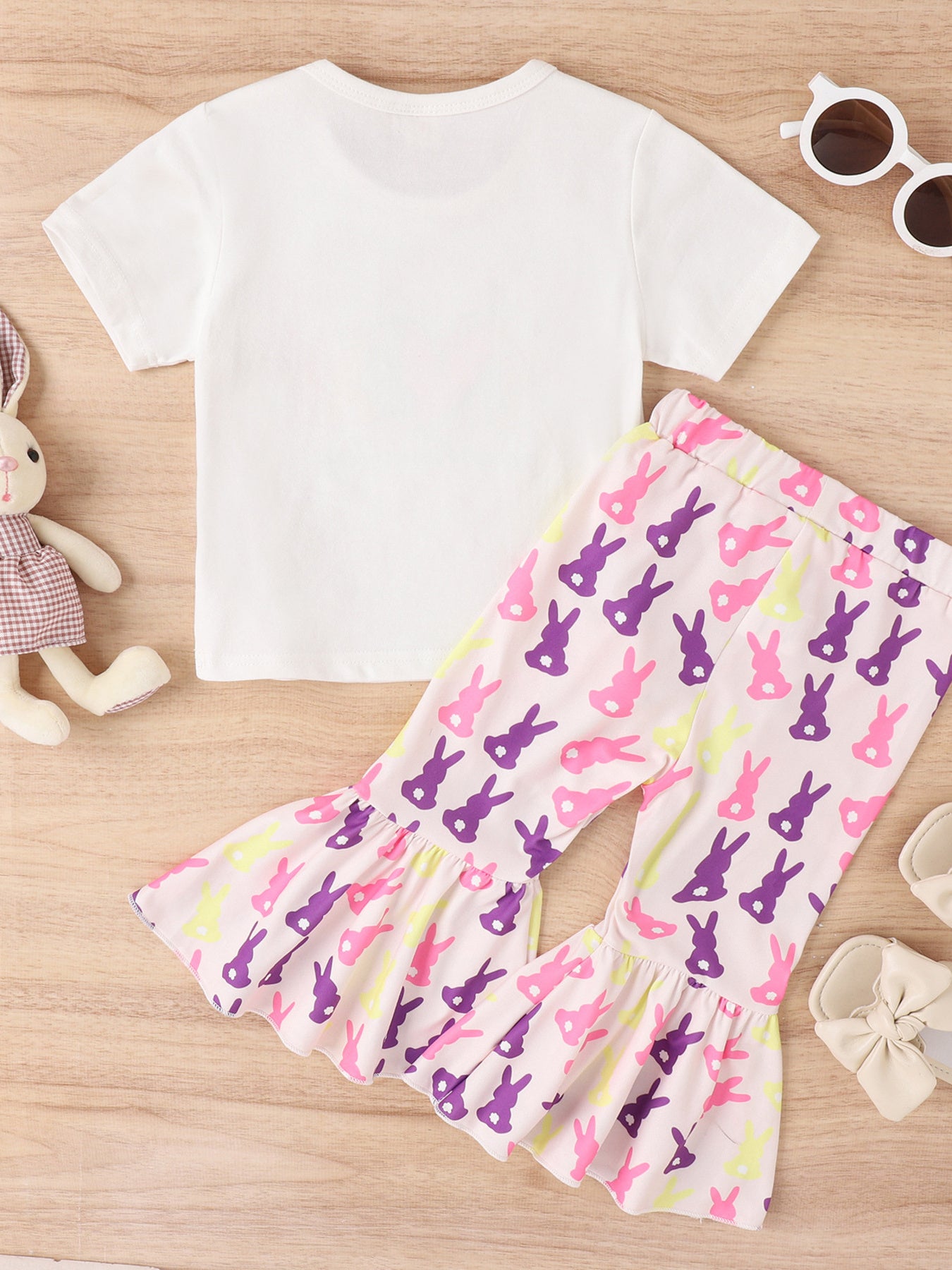 Baby set with white tee and pink bell-bottom pants featuring a purple, pink, and yellow bunny print.