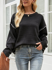 Black acrylic knit sweater with contrast stitching on sleeves and relaxed shoulders.