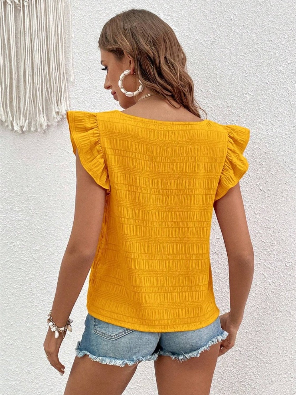 Yellow textured ruffle sleeve square neck blouse with smocked detail.