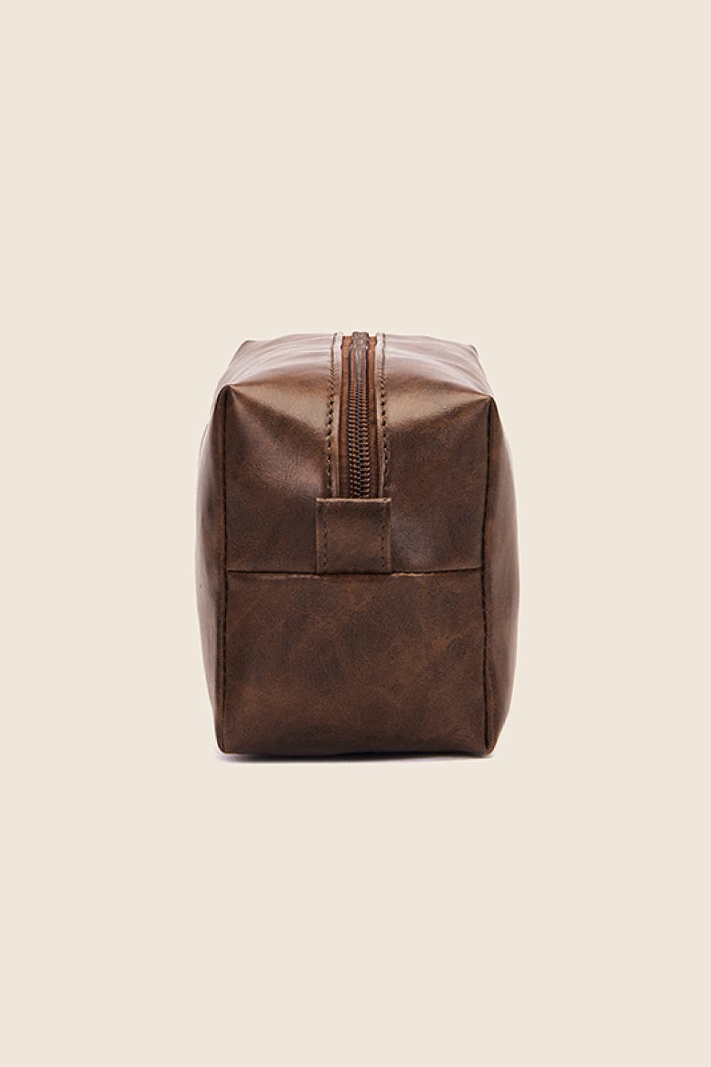 Textured faux leather travel case in caramel with a zipper closure and carry handle.