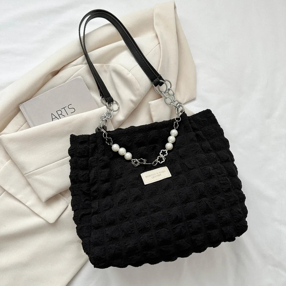 Black textured grid shopper bag with pearl and chain detail.