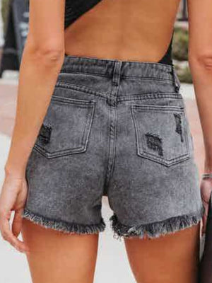 Black distressed denim shorts with frayed hem and crystal fringe detail.