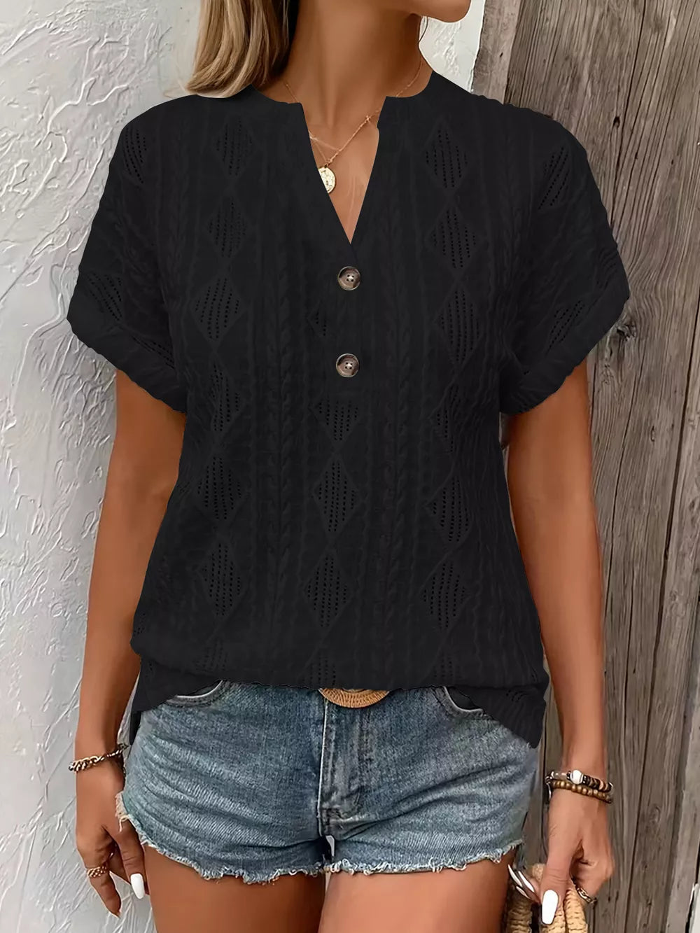 Black short-sleeve t-shirt with diamond pattern and button detail.