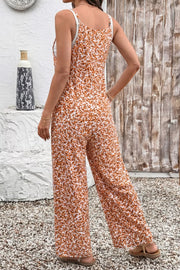 Abstract floral wide-leg romper with adjustable straps and white lining.