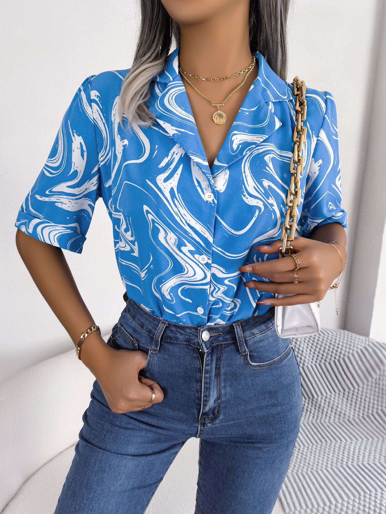 Sky blue swirl print camp collar blouse with short sleeves.