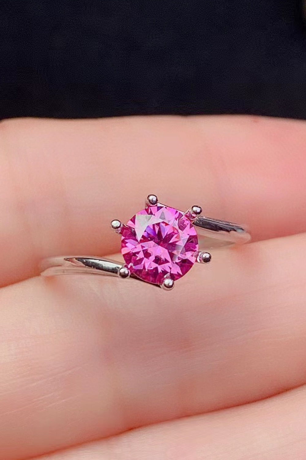 Radiant pink moissanite solitaire ring with a silver band.