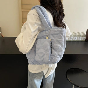 Quilted light blue shopper bag with front zip pocket and tassel detail