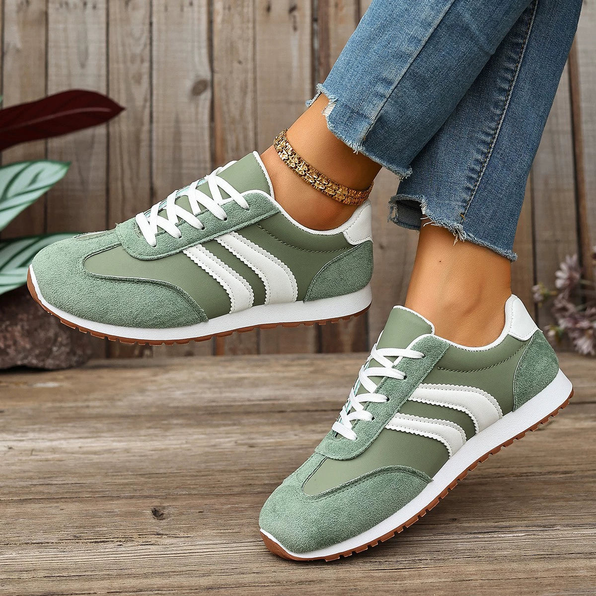Green suede lace-up sneakers with white stripes and brown soles