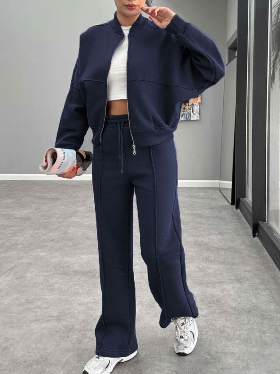Dark blue bomber jacket and wide-leg tracksuit with drawstring waist and contrast stitching.