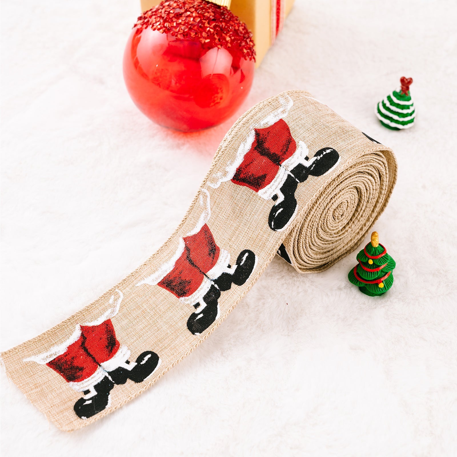 Burlap ribbon with Santa legs pattern, beige, for holiday crafts.