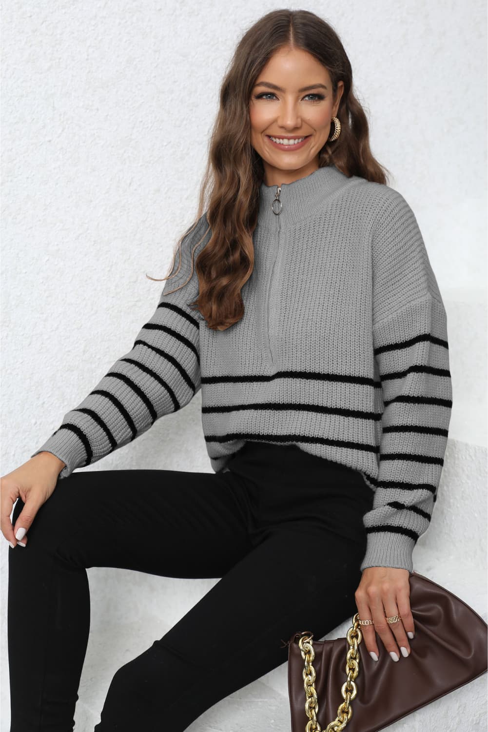 Striped ribbed knit quarter-zip sweater in gray with black stripes.