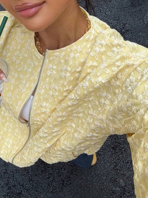 Yellow bomber jacket with textured floral embossing and zip closure