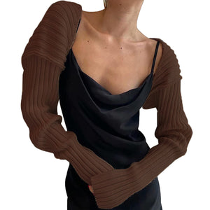 Brown ribbed knit shrug with extended sleeves worn over a black slip dress