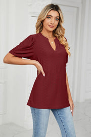 Wine perforated puff sleeve blouse with keyhole neckline and textured pattern.