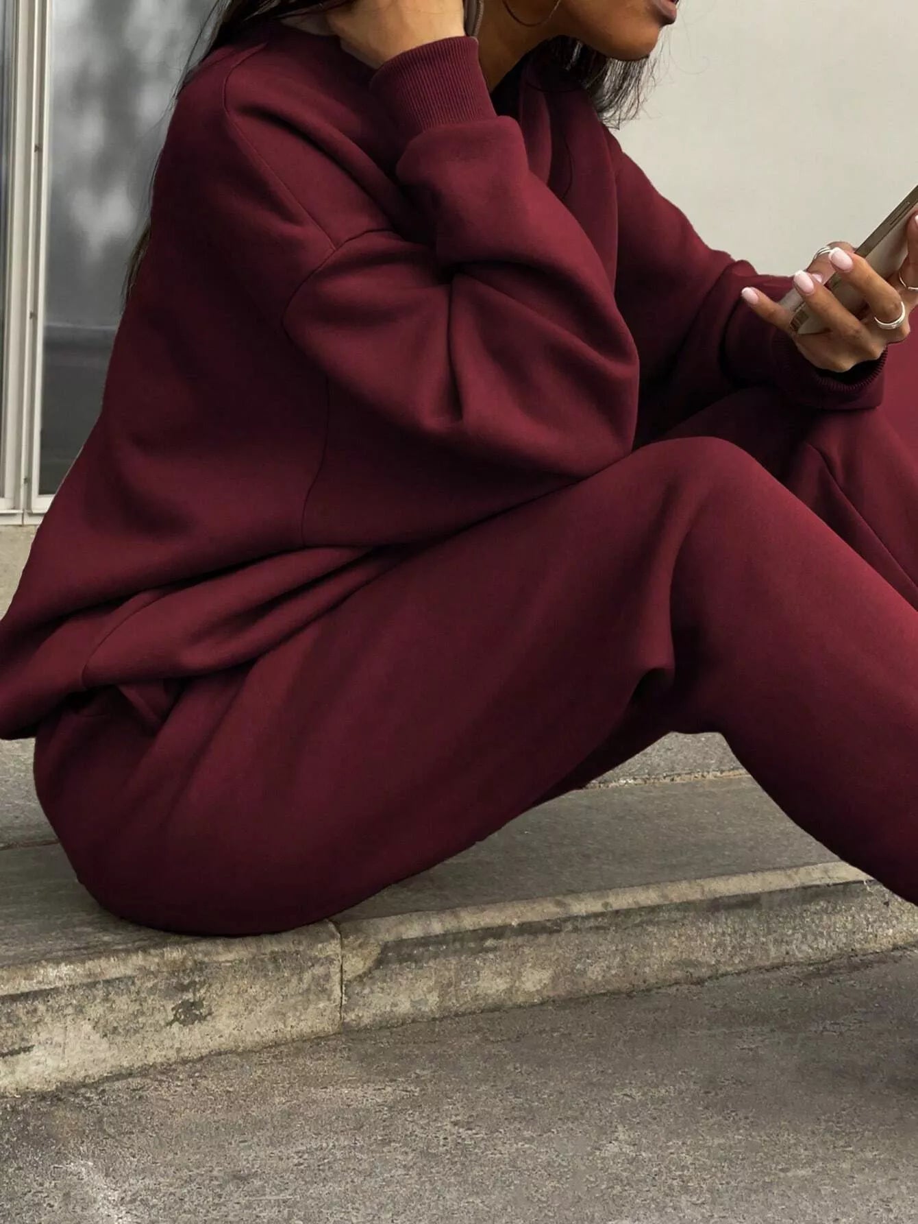 Burgundy sweatshirt and pants set with crewneck and cuffed sleeves, comfortable athleisure style.