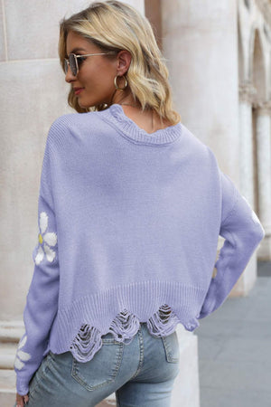 Purple distressed knit sweater with daisy appliqué and frayed hem.