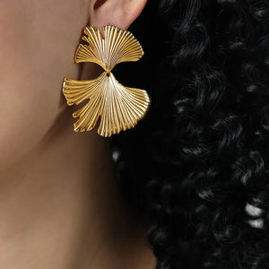 Gold Ginkgo leaf statement earrings with textured detail.