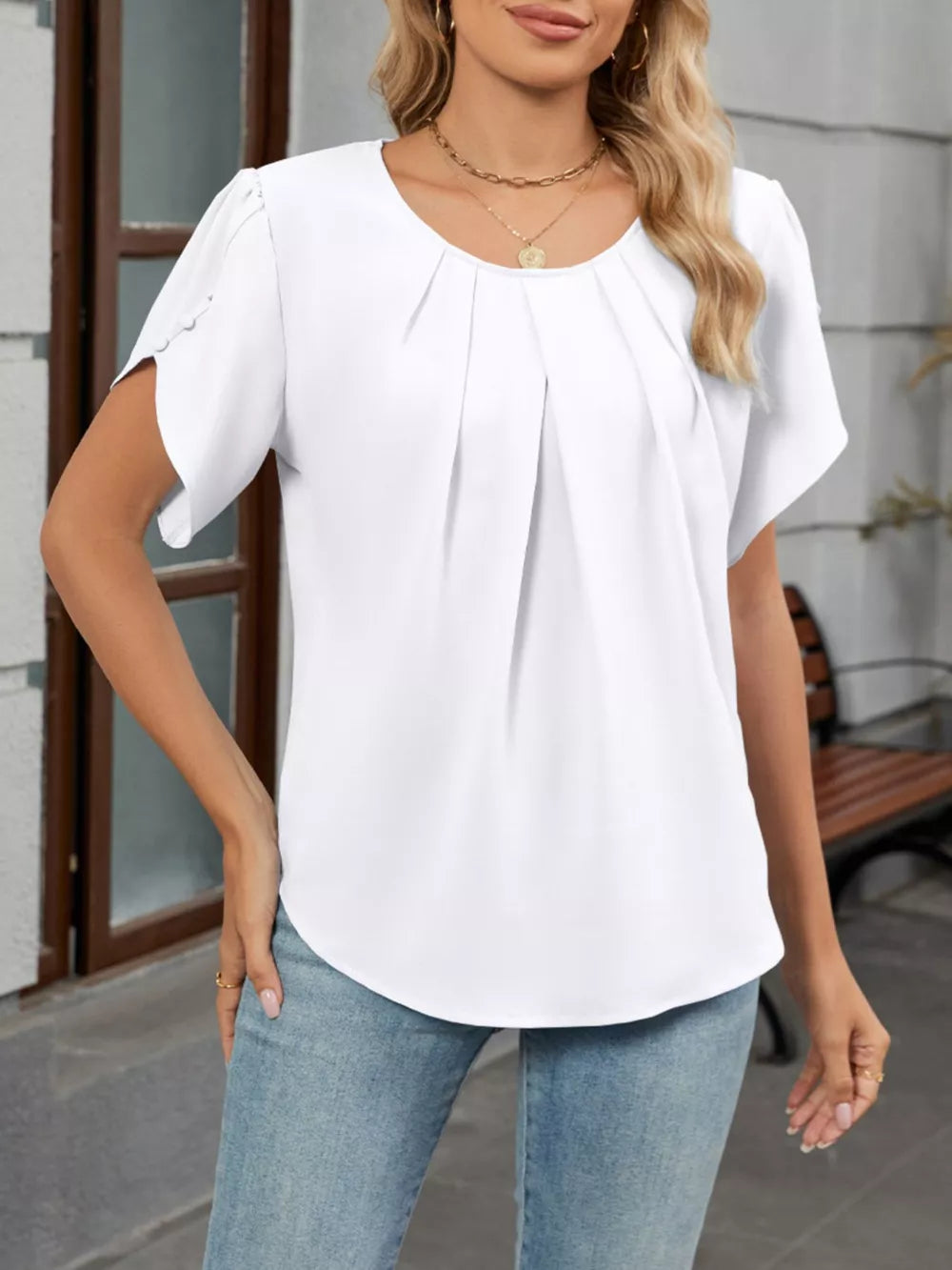 White polyester blouse with short sleeves and front pleats.