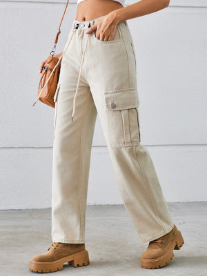 Tan denim cargo wide-leg trousers with drawstring waist and buttoned flap pockets.
