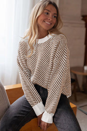 Chevron knit crewneck sweater in camel and white with white cuffs.