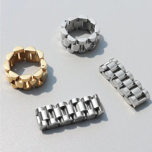 Gold and silver watch link statement rings shown from multiple angles.