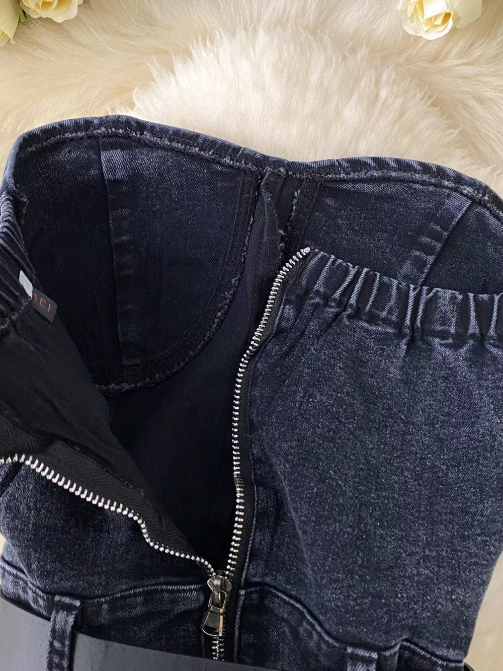 Black denim bustier bodysuit with front zipper and elasticized back detail