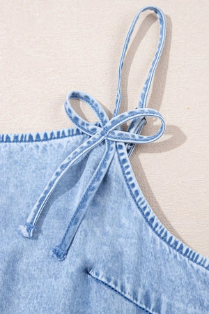 Light blue denim sundress with tie straps and ruffled hem detail.