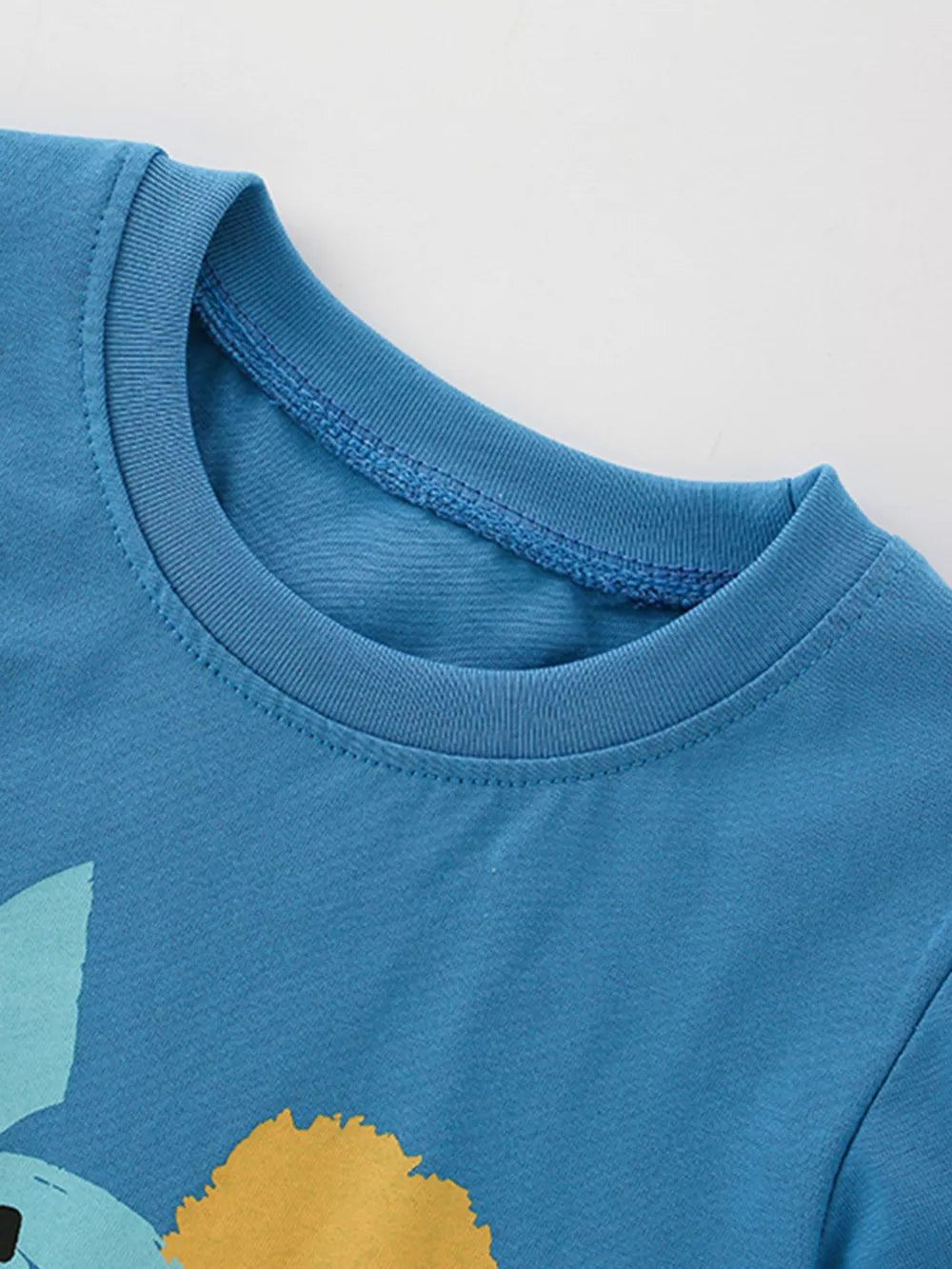 Toddler graphic tee in cerulean cotton with abstract dinosaur graphic detail.