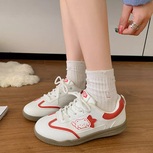 White lace-up sneakers with red trim and a cute cartoon cat accent.