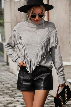 Light gray turtleneck sweater with chevron fringe detail and textured knit.