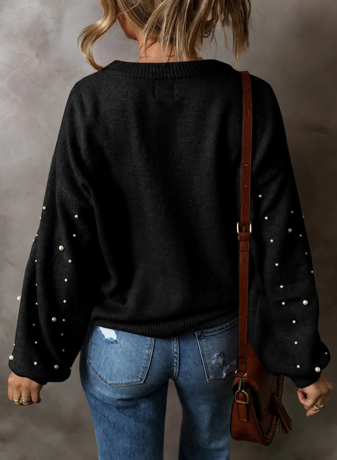Black long sleeve sweater with pearl embellishments on the sleeves.